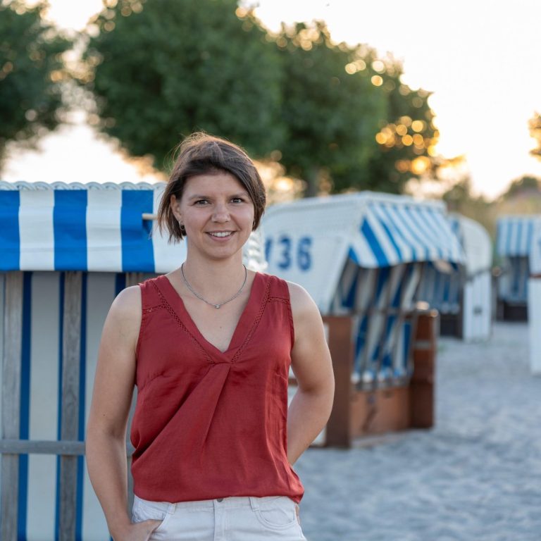 Sophie Rödiger am Strand, im Hintergrund mehrere Strandkörbe